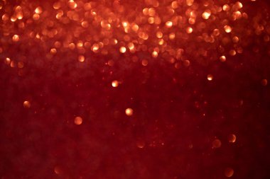 Shiny red blurred background for holiday design. Christmas abstract sparkles, selective focus