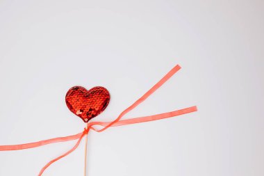 Red heart in sequins on a white background. Valentines Day background. Flat lay