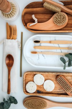 Set of wooden eco friendly devices. Brushes, washcloth, natural soap, cutlery on a white background. Flat lay