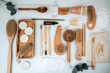 Ahşap çevre dostu cihazlar. Fırçalar, bez ve kulak çubukları, doğal sabun, beyaz arka planda tekstil torbaları. Düz yatıyordu