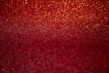 Shiny red blurred background for holiday design. Christmas abstract sparkles, selective focus
