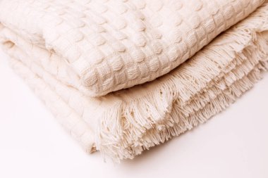 Textured background for design. Light beige knitted fabric with a checkered pattern, front view