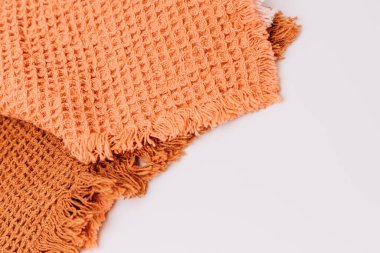 Background for design. Waffle fabrics in orange, brown and pink with fringes. Top view