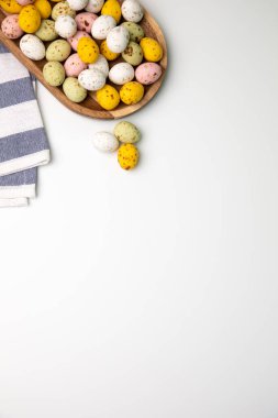 Beyaz arka planda ahşap tabakta çok renkli çikolata dekoratif yumurtalar. Mutlu Paskalyalar. Üst görünüm