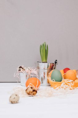 Beyaz ahşap arka planda sarı bir karton tepside çok renkli yumurtalar boyadım. Paskalya arkaplanı, sembol. Ön görünüm