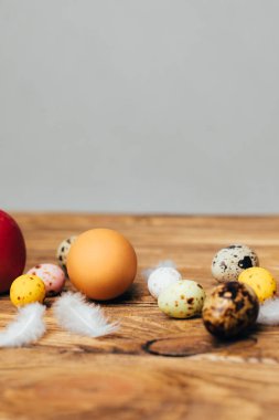 Kahverengi ahşap arka planda farklı boyutlarda renkli yumurtalar. Paskalya bayramının sembolü. Paskalya arkaplanı, ön görünüm