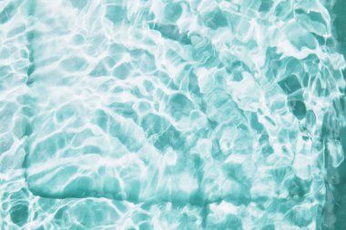 Soyut doğa arka planda, su dalgaları güneş yansıması ile birlikte havuzda. Mavi zemin üzerinde kabarcıklar ve daireler olan berrak su