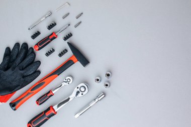 Bir takım çalışma aletleri, bir çekiç, bir tornavida, iş eldivenli gri beton arka planda bir cevap için soketler. Düz yatıyordu