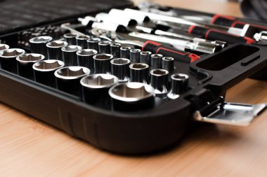 Siyah plastik torba içinde çalışma aletleri, bir tornavida, ayarlanabilir anahtarlar, bambuyu tamir etmek için soketler, ahşap arka plan. Ön görünüm