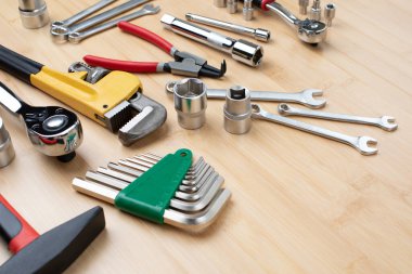 Bir takım çalışma aletleri, bir çekiç, bir tornavida, ayarlanabilir anahtarlar, bambudaki tamir için soketler, ahşap arka plan. Üst görünüm