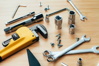 Bir takım çalışma aletleri, bir çekiç, bir tornavida, ayarlanabilir anahtarlar, bambudaki tamir için soketler, ahşap arka plan. Üst görünüm