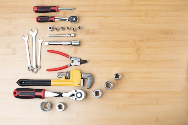 stock image A set of working tools, a hammer, a screwdriver, adjustable spanner, sockets for repair on a bamboo, wooden background. Flat lay