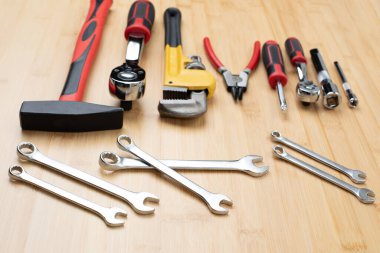 Bir takım çalışma aletleri, bir çekiç, bir tornavida, ayarlanabilir anahtarlar, bambudaki tamir için soketler, ahşap arka plan. Üst görünüm