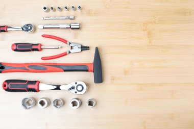 Bir takım çalışma aletleri, bir çekiç, bir tornavida, bambudaki tamir için soketler, ahşap arka plan. Düz yatıyordu