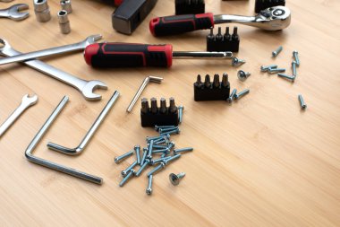 Bir takım çalışma aletleri, bir çekiç, bir tornavida, bambudaki tamir için soketler, ahşap arka plan. Ön görünüm