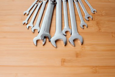 Bir takım çalışma aletleri, kahverengi ahşap üzerinde farklı boyutlarda anahtarlar, bambu arka plan. Üst görünüm