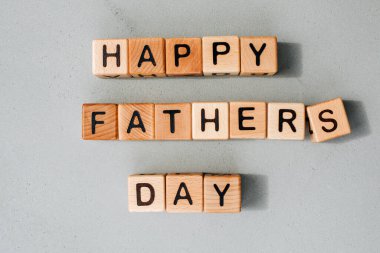 Mutlu Babalar Günü konsepti. Geçmiş, tebrik kartı. Gri beton arka planda siyah harfli tahta küpler serili. Düz yatıyordu