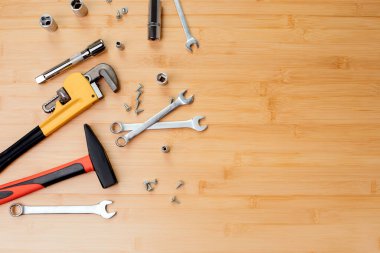 Bir takım çalışma aletleri, bir çekiç, bir tornavida, ayarlanabilir anahtarlar, bambudaki tamir için soketler, ahşap arka plan. Düz yatıyordu