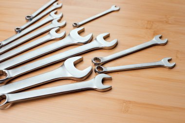 Bir takım çalışma aletleri, kahverengi ahşap üzerinde farklı boyutlarda anahtarlar, bambu arka plan. Üst görünüm