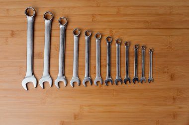 Bir takım çalışma aletleri, kahverengi ahşap üzerinde farklı boyutlarda anahtarlar, bambu arka plan. Üst görünüm