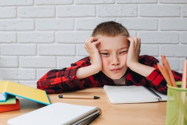 Konsepti okula geri götür. Öğrenim sürecinde olan bir çocuk, unigami, defter ve kalemlerle aynı masada oturuyor. Ön görünüm