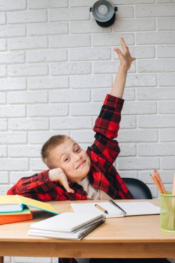 Konsepti okula geri götür. Ders çalışma sürecinde olan bir çocuk kitaplar, defterler ve kalemlerle bir masada oturur. Ön görünüm
