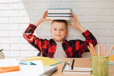 Konsepti okula geri götür. Ders çalışma sürecinde olan bir çocuk kitaplar, defterler ve kalemlerle bir masada oturur. Ön görünüm
