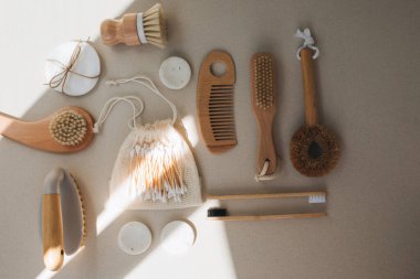 Ahşap çevre dostu cihazlar. Fırçalar, el bezi ve kulak çubukları, bej beton arka planda doğal sabun. Düz yatıyordu