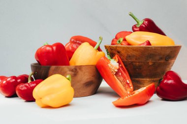 Beton bir arka planda tahta tabaklarda farklı boyutlarda dolmalık biberler. Bahçe arka planı, dolmalık biber hasadı. Olgunlaşmış kırmızı kağıt. Üst görünüm