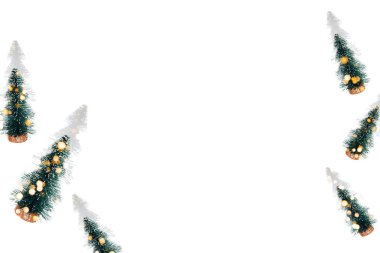 Beyaz arka planda gölgeleri olan küçük yeşil dekoratif Noel ağaçları olan bir arka plan. Boş alanı olan kart. Dümdüz uzanmış Noel deseni