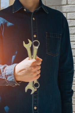 Çalışma aletleri, erkek elinde farklı boyutlarda anahtarlar. Ön görünüm