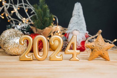 Yeni yıl, Noel geçmişi. 2024 numaralı mum. Ahşap ve siyah arka planda dekoratif küçük noel cüceleri. Ön görünüm