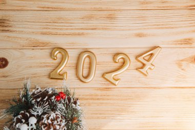 Boşluklu selamlama arkaplanı. Mutlu yıllar kartı. Hafif ahşap arka planda 2024 rakamları var. Üst görünüm