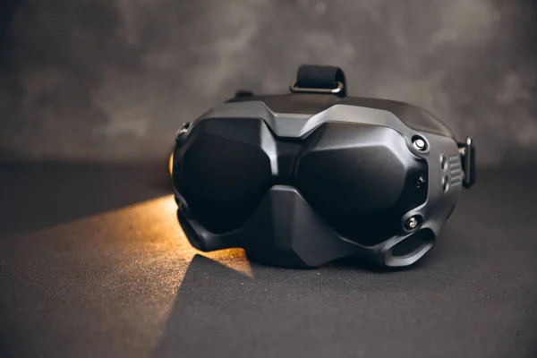 Close-up of black virtual reality glasses on a black concrete background. Glasses for controlling drones. Front view