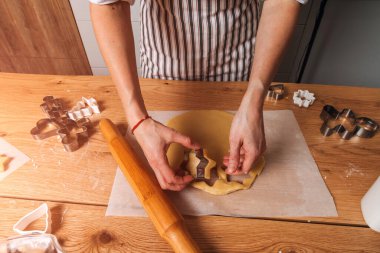 Kadınların ellerini yakın, mutfaktaki ahşap bir masanın üzerinde bir yıldız şeklinde kurabiye yapıyorlar. Evde yemek pişirme tatlısı. Üst görünüm