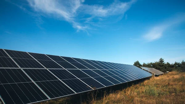 Gündüz vakti dışarıdaki büyük pilli paneller. Alternatif elektrik, yeşil ekonomi. Güneş panelleri olan bir arka plan. Ön görünüm, web pankartı