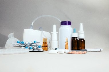 Şişelerde ve tabletlerde, şeffaf plakalarda hafif arka planda tedavi için bir takım ilaçlar. Ön görünüm