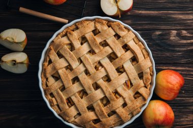 Elmalı turta mavi formda koyu ahşap arka planda ve kırmızı elmalı. Hazır turta. Üst görünüm