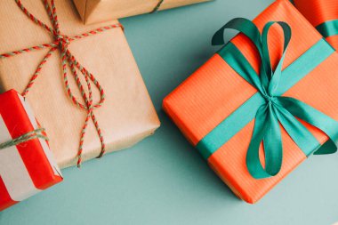 Noel, şenlikli bir geçmiş. Yeşil arka planda kırmızı ve kahverengi kağıtlara sarılı hediyeler. Üst görünüm