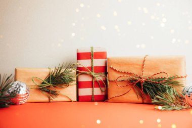 Noel 'i kutlamak, yeni yıl geçmişi. Kırmızı ve bej arka planda kahverengi ve kırmızı kağıtlara sarılmış hediyeler. Ön görünüm