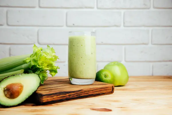 Fruit and vegetable smoothies in glass. Green smoothie on a wooden table. The concept of healthy eating. Front view