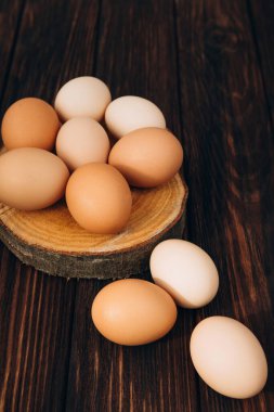 Farklı kahverengi ve bej renkte tavuk yumurtaları. Tahta bir yuvarlak tahta masa üzerinde. Paskalya geçmişi. Ön görünüm
