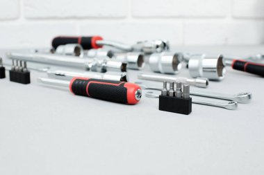 Bir takım çalışma aletleri, bir çekiç, bir tornavida, gri beton arka planda bir cevap için soketler. Ön görünüm