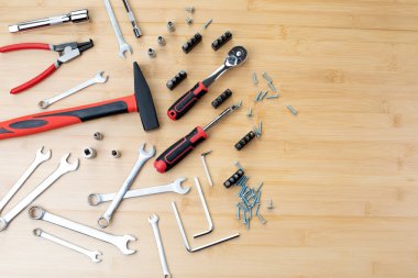 Bir takım çalışma aletleri, bir çekiç, bir tornavida, bambudaki tamir için soketler, ahşap arka plan. Üst görünüm