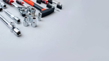 Bir takım çalışma aletleri, bir çekiç, bir tornavida, gri beton arka planda bir cevap için soketler. Üst görünüm, web pankartı
