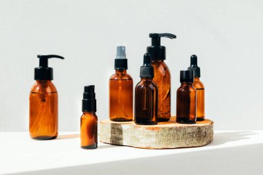 Doğal kozmetik seti. Kehribar şişeleri yüz maskesi, banyo sıvısı ahşap barın üzerinde beton bir arka plan. Ön görünüm