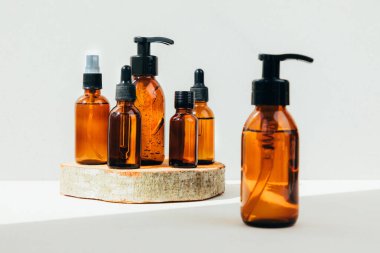 Doğal kozmetik seti. Kehribar şişeleri yüz maskesi, banyo sıvısı ahşap barın üzerinde beton bir arka plan. Ön görünüm