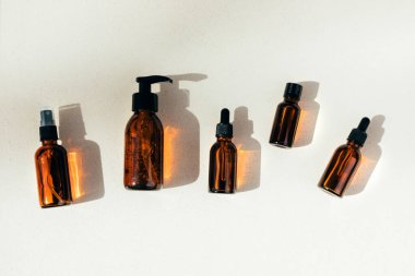 Doğal kozmetik seti. Kehribar şişeleri yüz maskesi, banyo sıvısı ahşap barın üzerinde beton bir arka plan. Üst görünüm