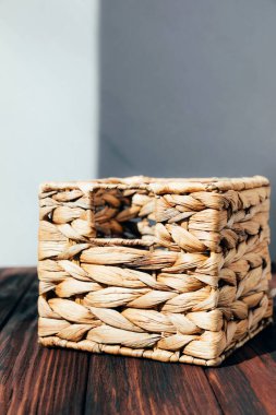 Ahşap arka planda bir şeyler saklamak için saman hasır keçi. Ön görünüm