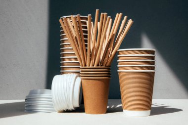 Gri arka planda bir takım kağıt çatal bıçak takımı ve ahşap çatal bıçak takımı. Çevre dostu, sıfır atık konsepti. Ön görünüm